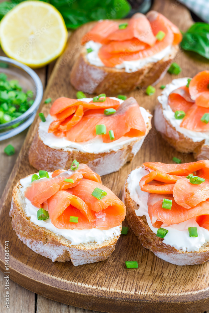 Sandwich with smoked salmon and cream cheese, wooden board, vertical Sandwich with smoked salmon and cream cheese, wooden board, vertical