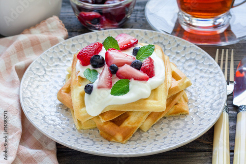 Homemade belgian waffles with yogurt, strawberry and blueberry, breakfast time