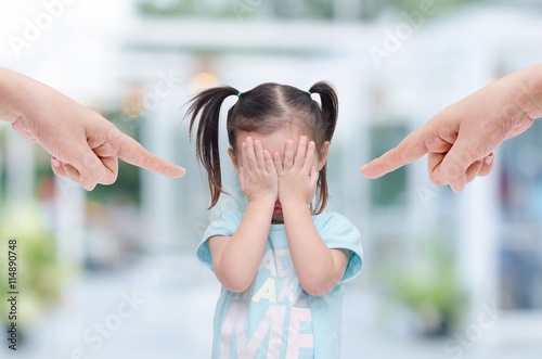 Little asian girl crying while parents scold her