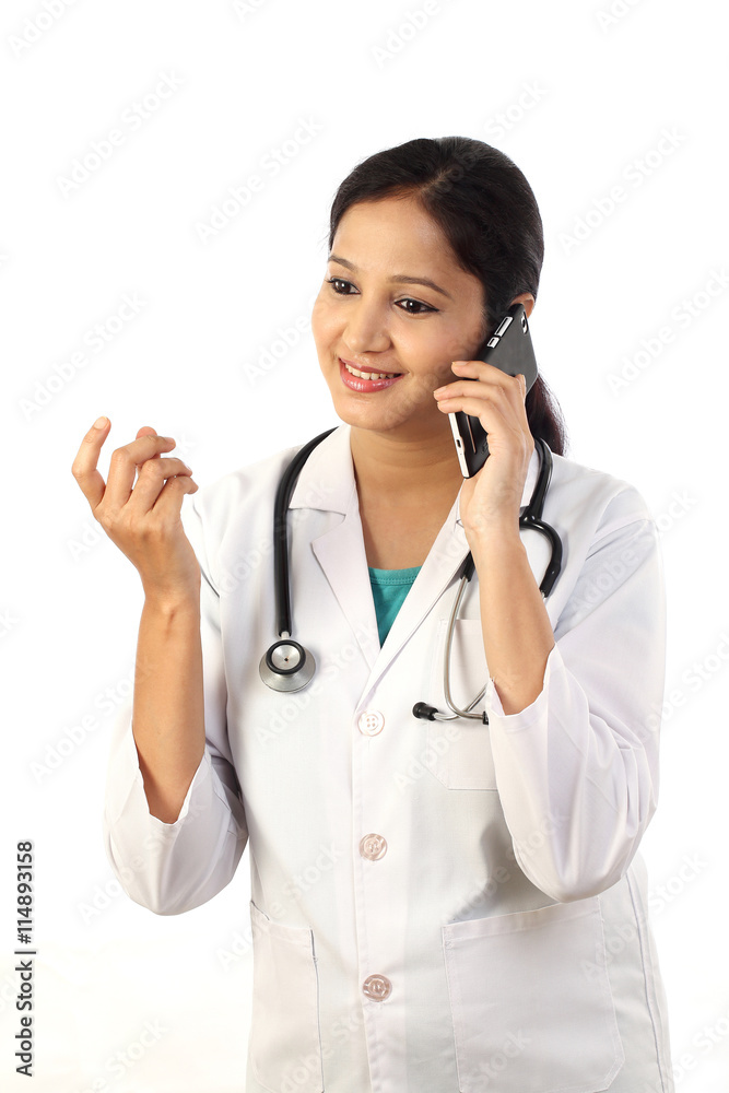 Young female doctor talking on mobile phone Young female doctor talking on mobile phone