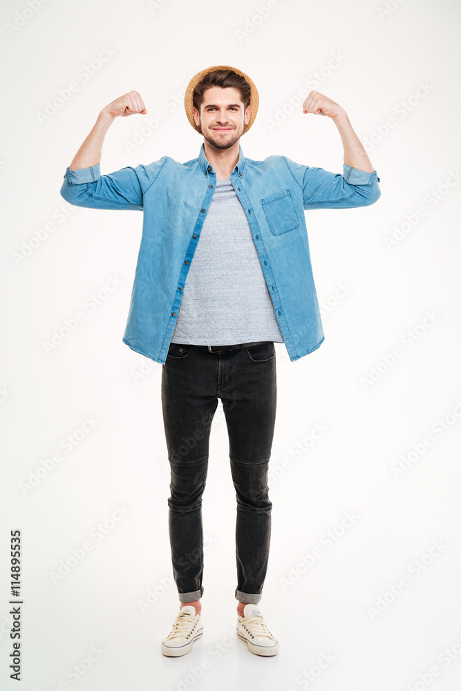 Happy handsome young man standing and showing biceps Happy handsome young man standing and showing biceps