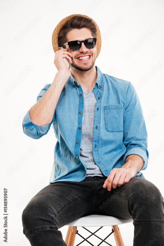 Smiling man sitting on chair and talking by cell phone Smiling man sitting on chair and talking by cell phone
