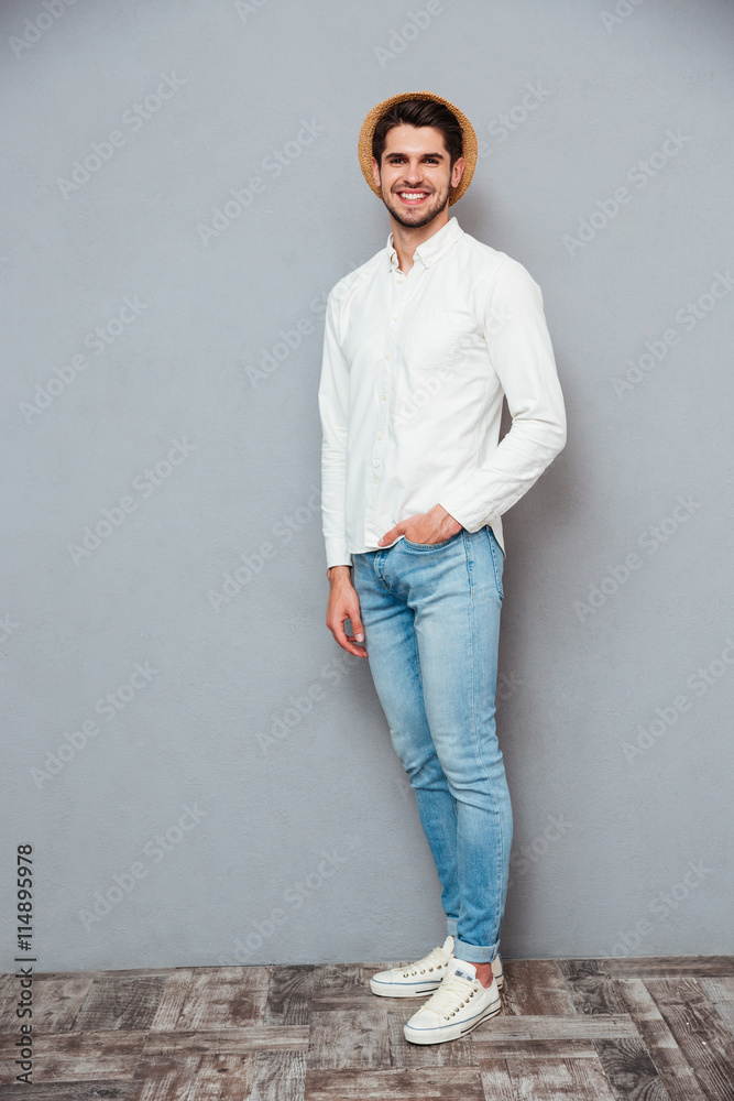 Happy handsome young man in white shirt, jeans and hat Happy handsome young man in white shirt, jeans and hat