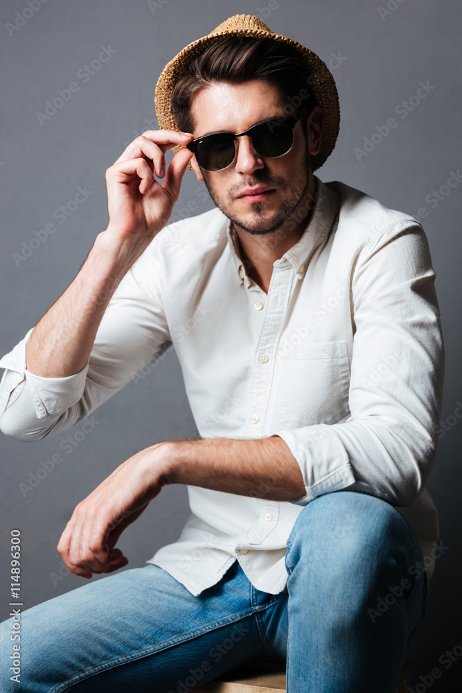 Fashion portrait of handsome young man in sunglasses and hat Fashion portrait of handsome young man in sunglasses and hat
