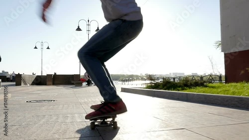 Skateboarder does trick at sunset photo