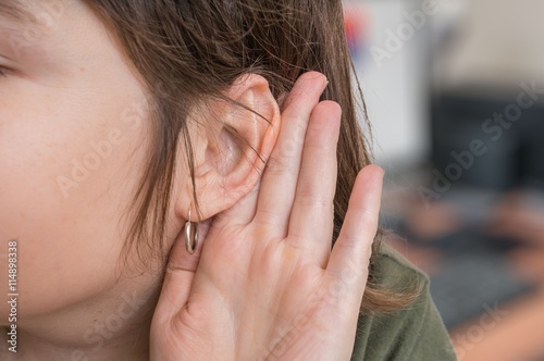Фотография Woman holds her hand near ear and listening carefully.