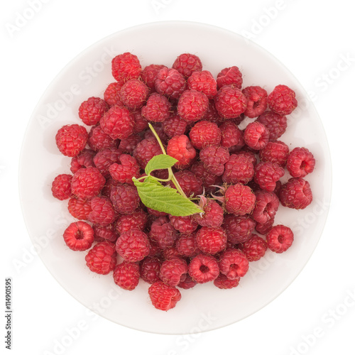 Plate with fresh raspberries on white background