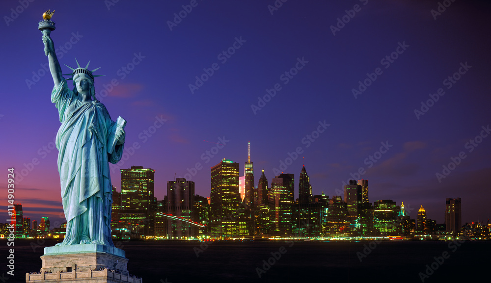Obraz premium Manhattan skyline at night and Statue of Liberty.
