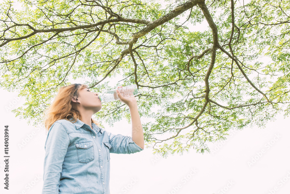 young beautiful woman drinking water at summer green park. young beautiful woman drinking water at summer green park.