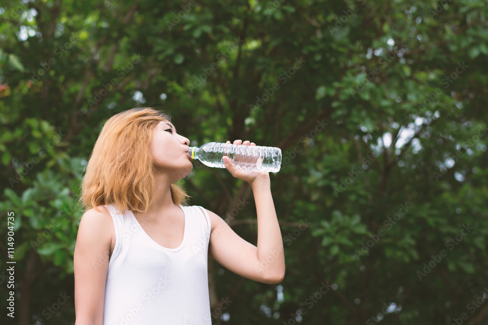 Young beautiful woman holding water at green park. Young beautiful woman holding water at green park.