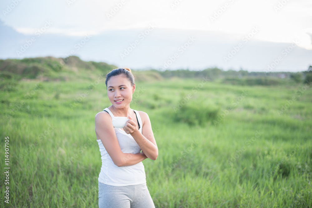Beautiful Asian woman drinking coffee in meadows. Beautiful Asian woman drinking coffee in meadows.