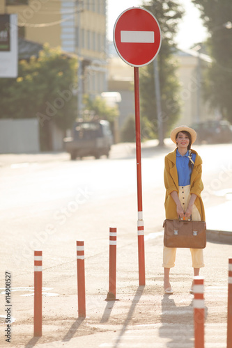 Young happy woman waves retro suitcase