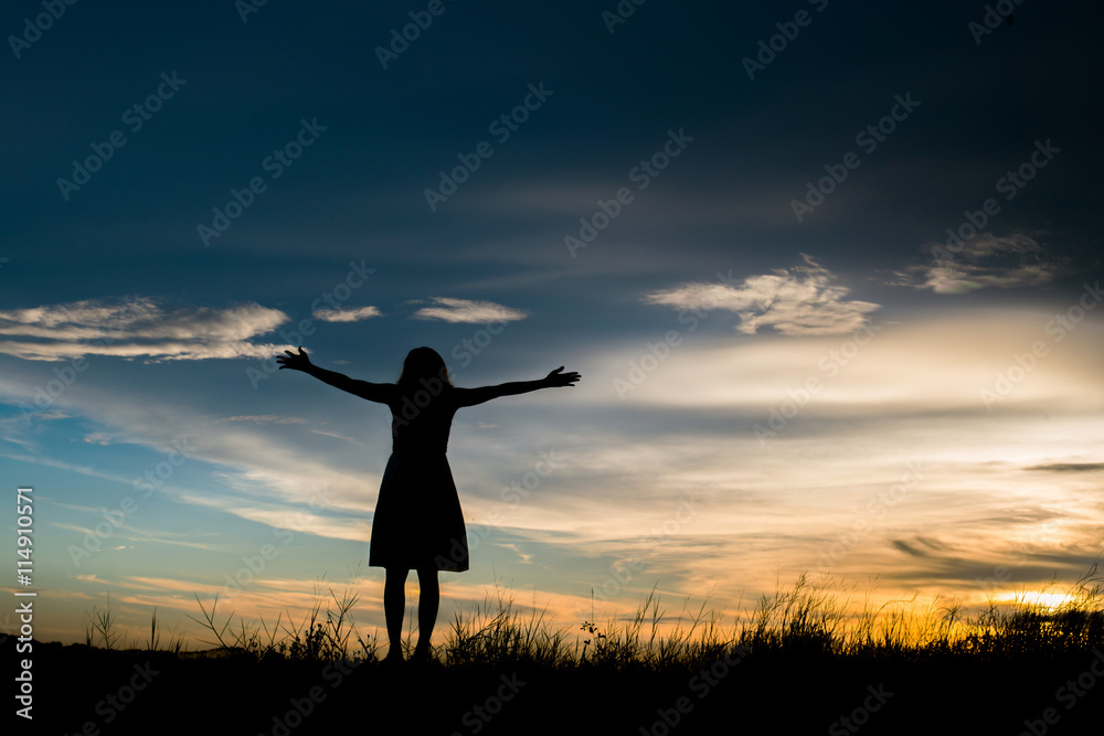 silhoutte of woman standing alone at the field during beautiful