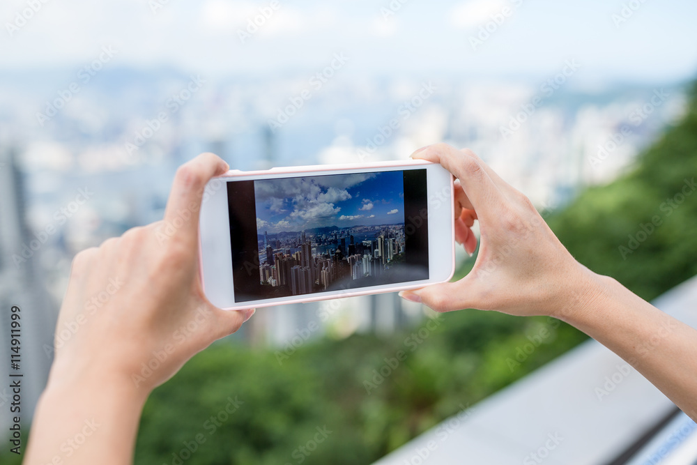 Woman taking photo on city view of Hong Kong with cellphone Woman taking photo on city view of Hong Kong with cellphone