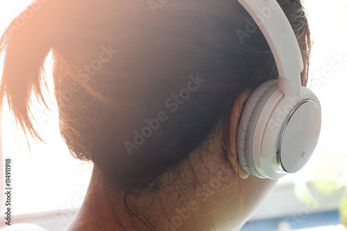 a girl using earphone with orange light