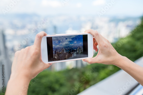 Woman taking photo on city view of Hong Kong with cellphone
