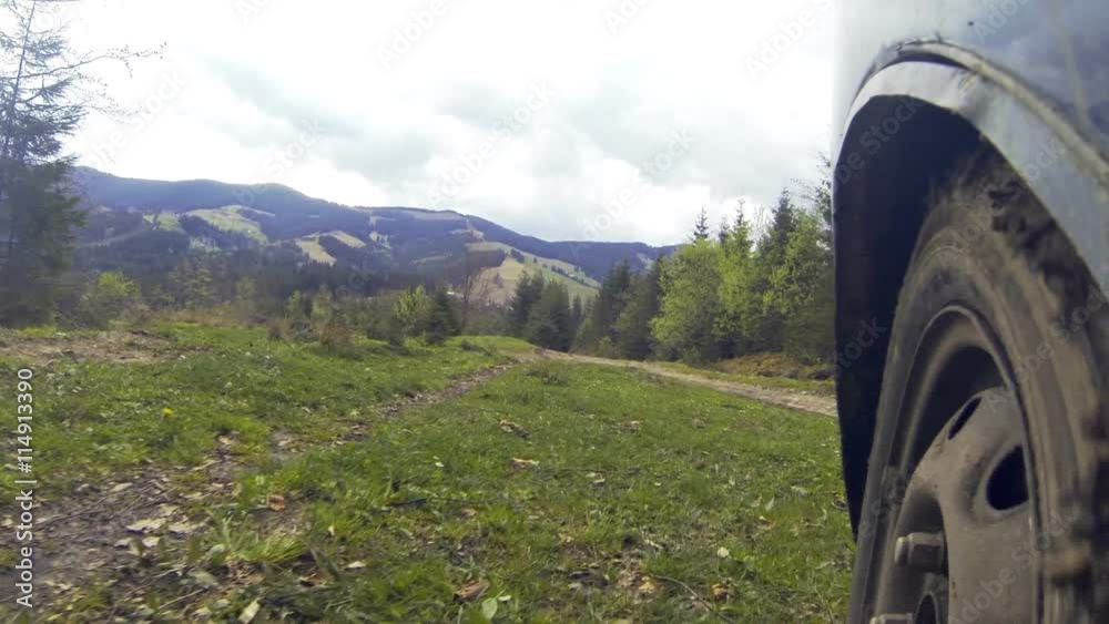 Car driving through the countryside in the mountains. The camera is left outside. Wiev on wheel. Car driving through the countryside in the mountains. The camera is left outside. Wiev on wheel.