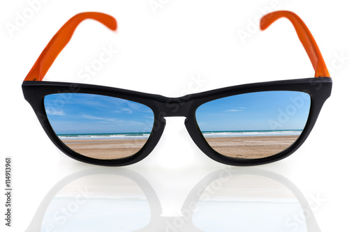 Beach and waves reflected in sunglasses on a white background.