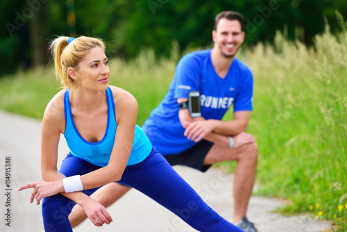 young health couple doing stretching exercise relaxing and warm up after jogging and running in park