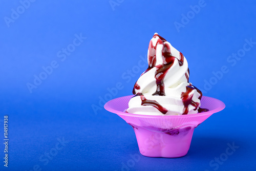 frozen yogurt with black cherry topping on blue background