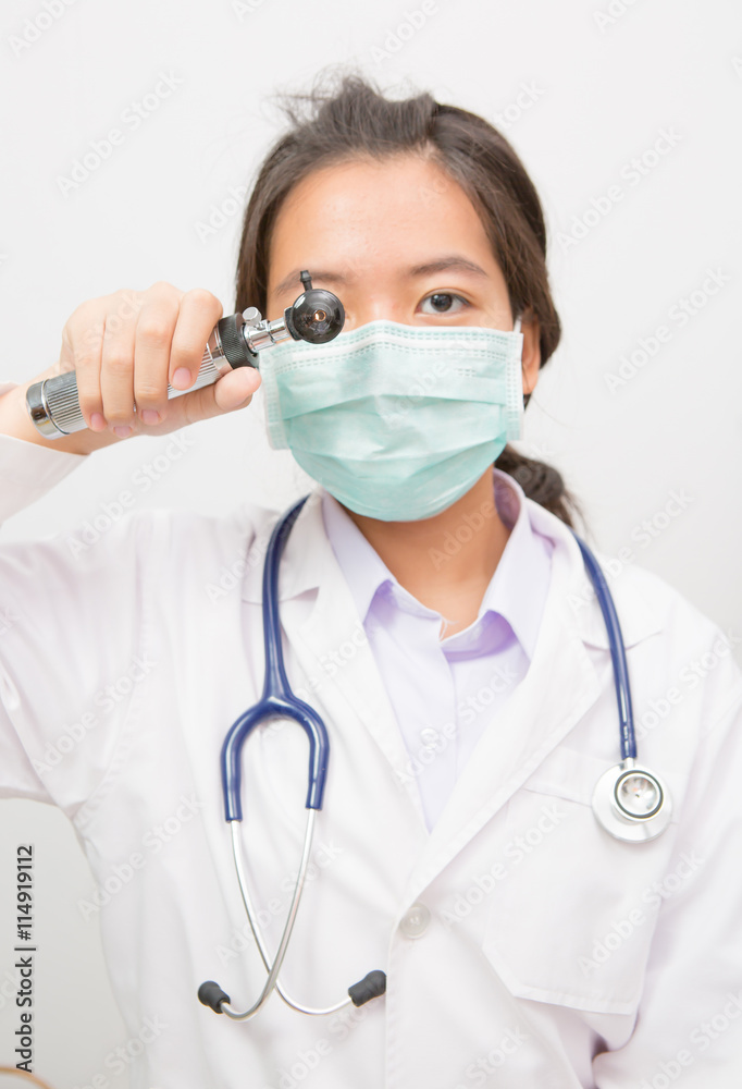 Doctor looks through otoscope instrument Doctor looks through otoscope instrument