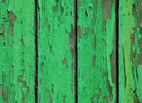 Old green painting remains on wooden wall