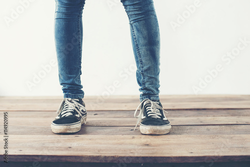 hipster cool woman feet with black sneakers, soft vintage toned