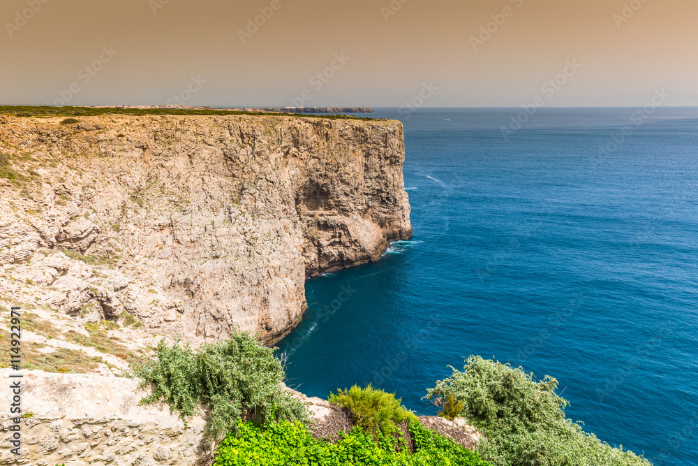 Fototapeta premium High cliffs and blue ocean at Cabo Sao Vicente on coast of Portu