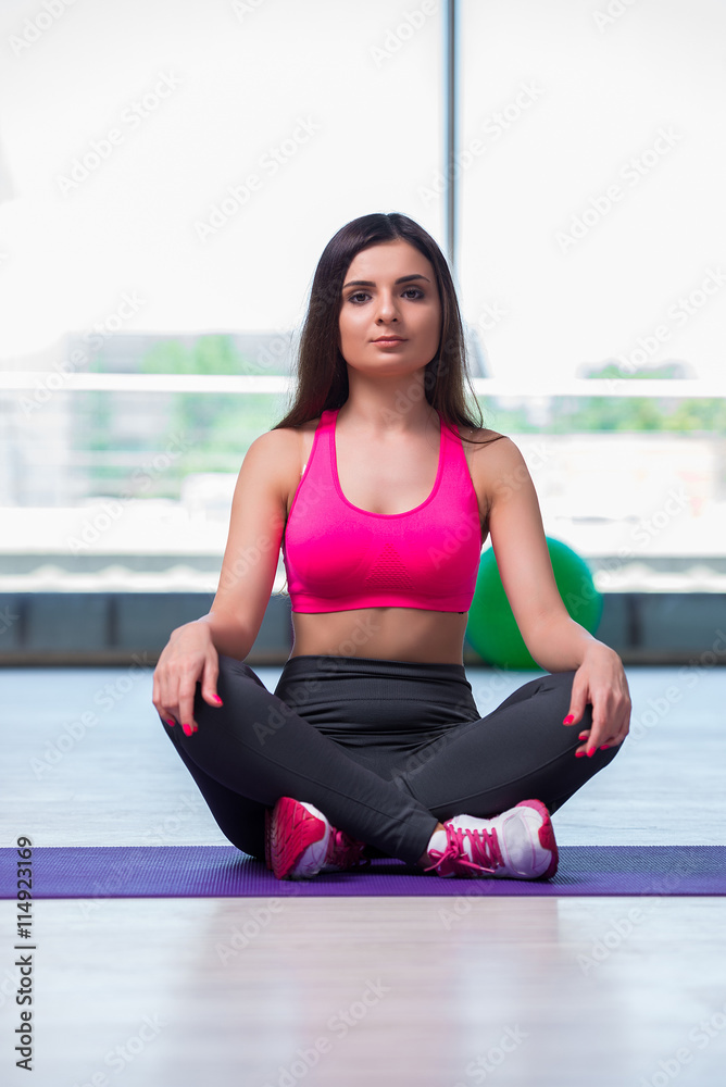Young woman meditating in gym health concept