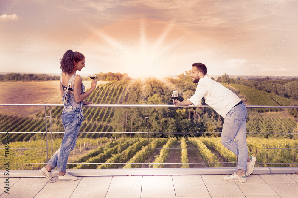 young couple toasting in a vineyard at sunrise