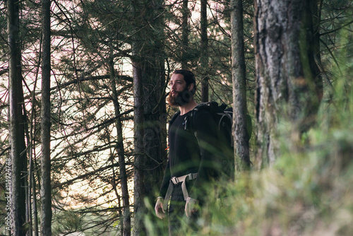 Hiker with beard and backpack in forest