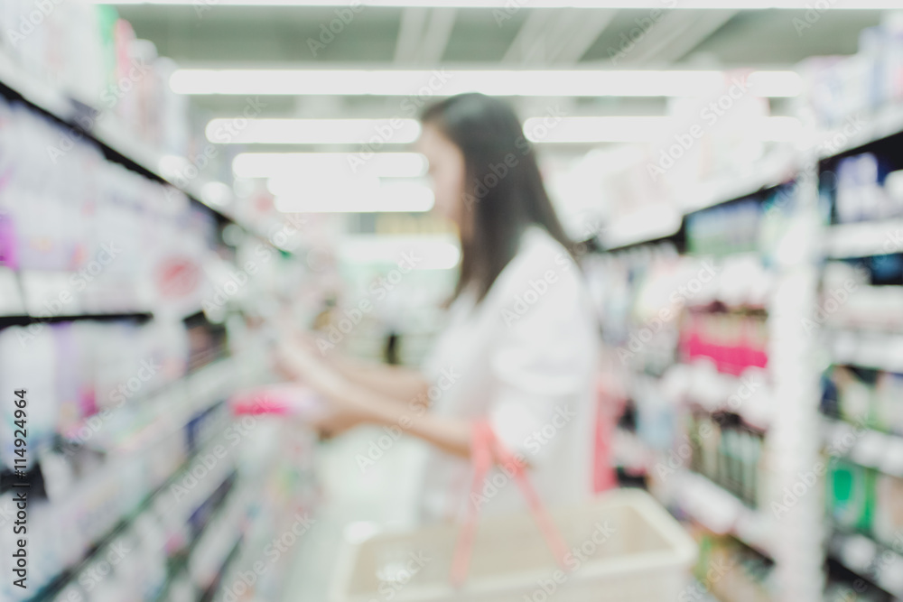 Blurred image of a woman with a shopping in the grocery store