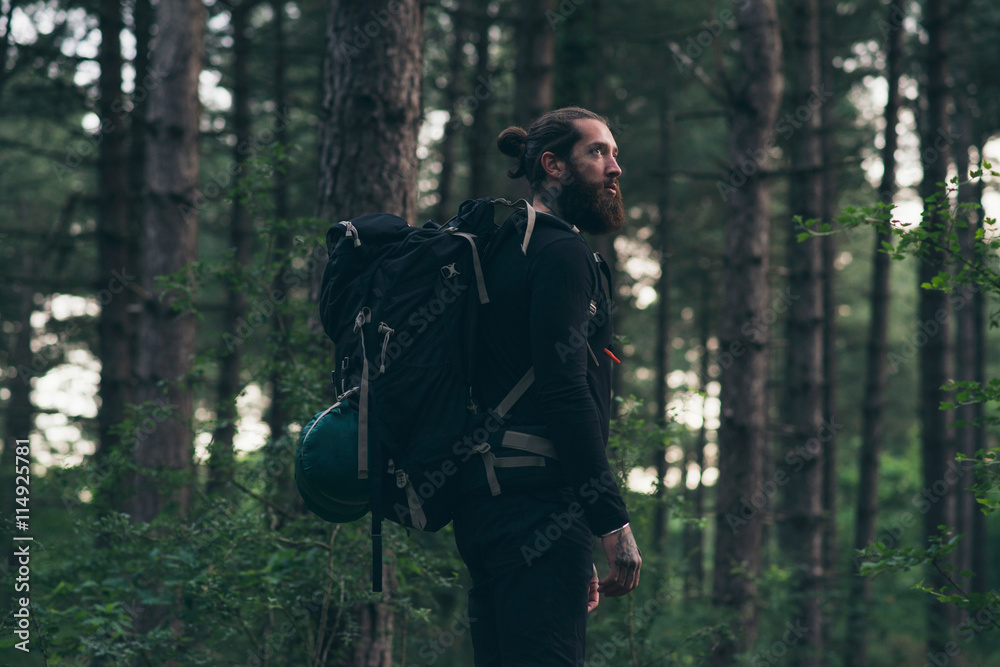 Beard man with backpack in forest