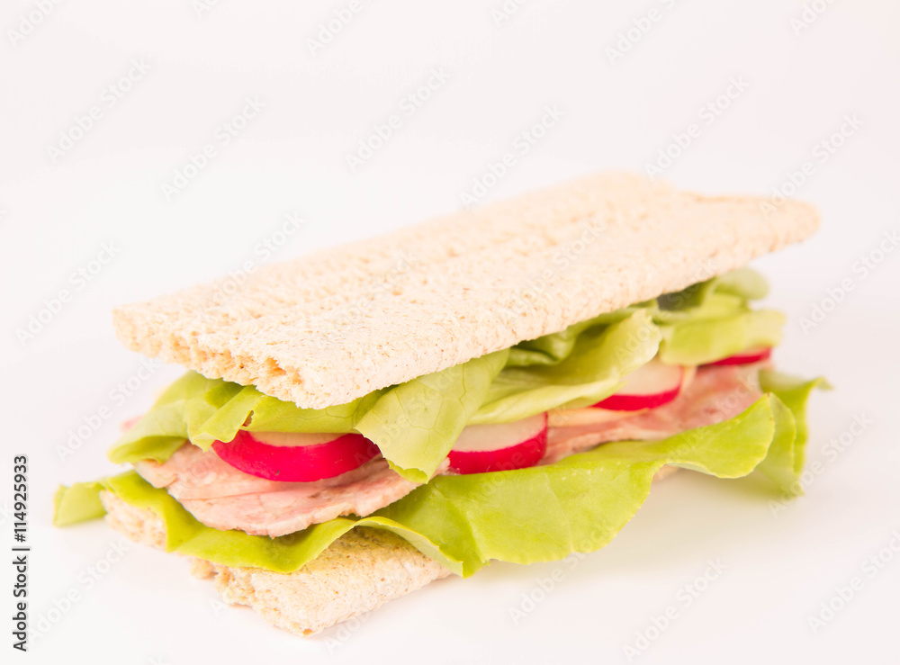 Crispbread sandwich with headcheese, cheese, radish and lettuce on a white background