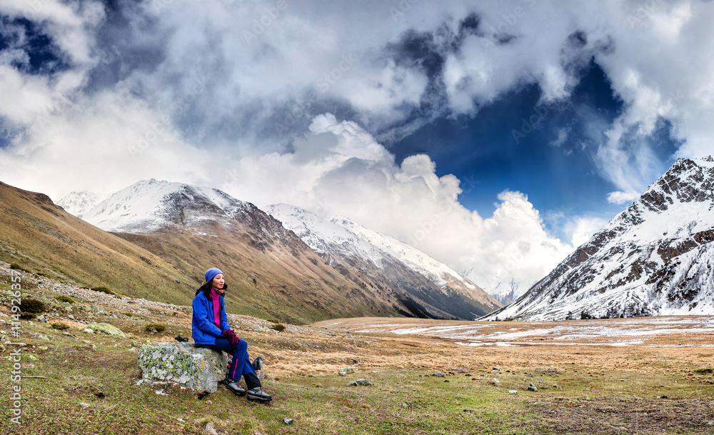 Fototapeta premium The girl has a rest after a difficult ascension in mountains