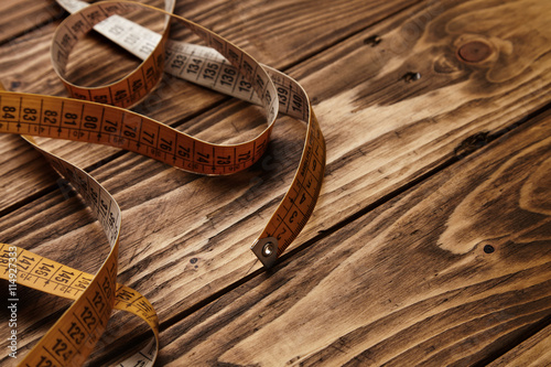 Vintage tailor ruler isolated on rustic wooden table photo