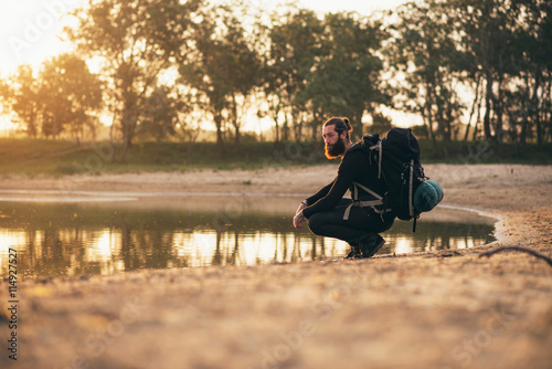 Hiker with beard resting at lake