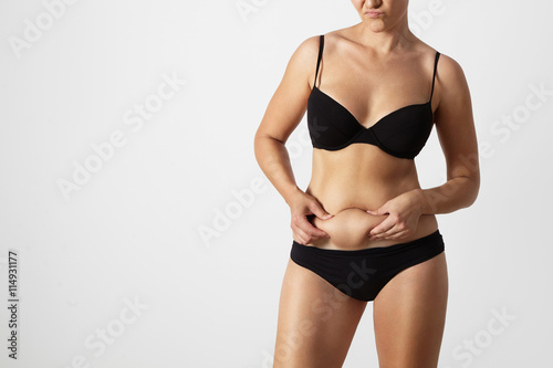 woman pinched her fat on abdomen