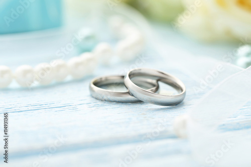 Silver wedding rings on a blue wooden table