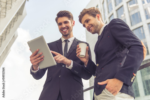 Handsome young businessmen with gadget