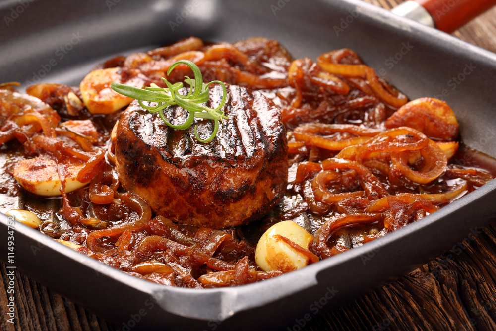 Grilled pork chop with onion on the pan on wooden background Grilled pork chop with onion on the pan on wooden background