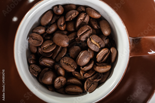 Brown cup with coffee seeds
