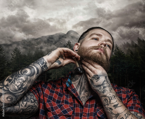 Shaving brutal tattooed male. photo