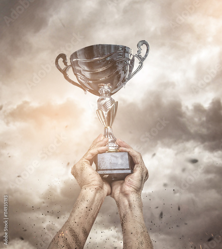 Cropped male arms with winner cup. photo