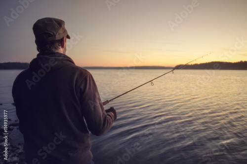 Angler am See nach Sonnenuntergang
