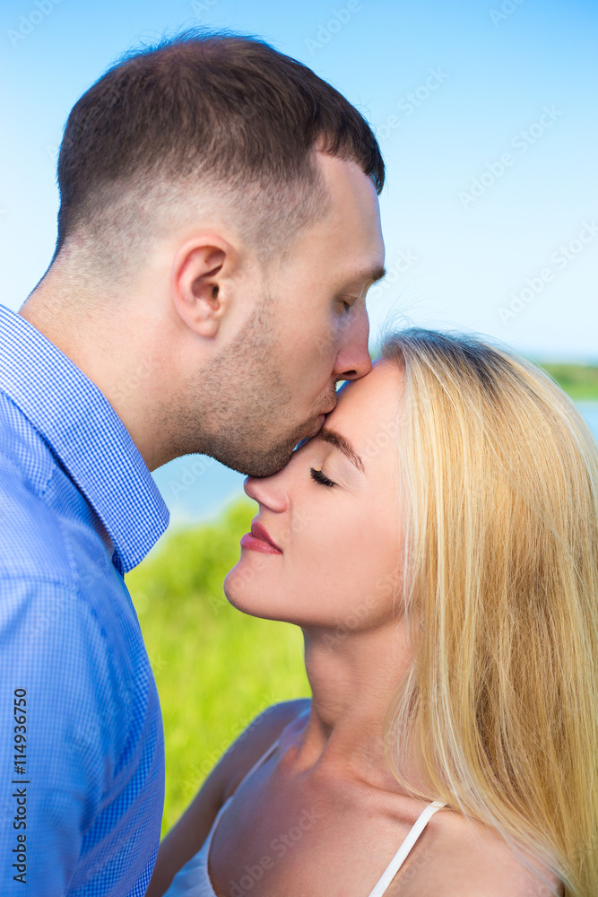 portrait of handsome man kissing his girlfriend portrait of handsome man kissing his girlfriend