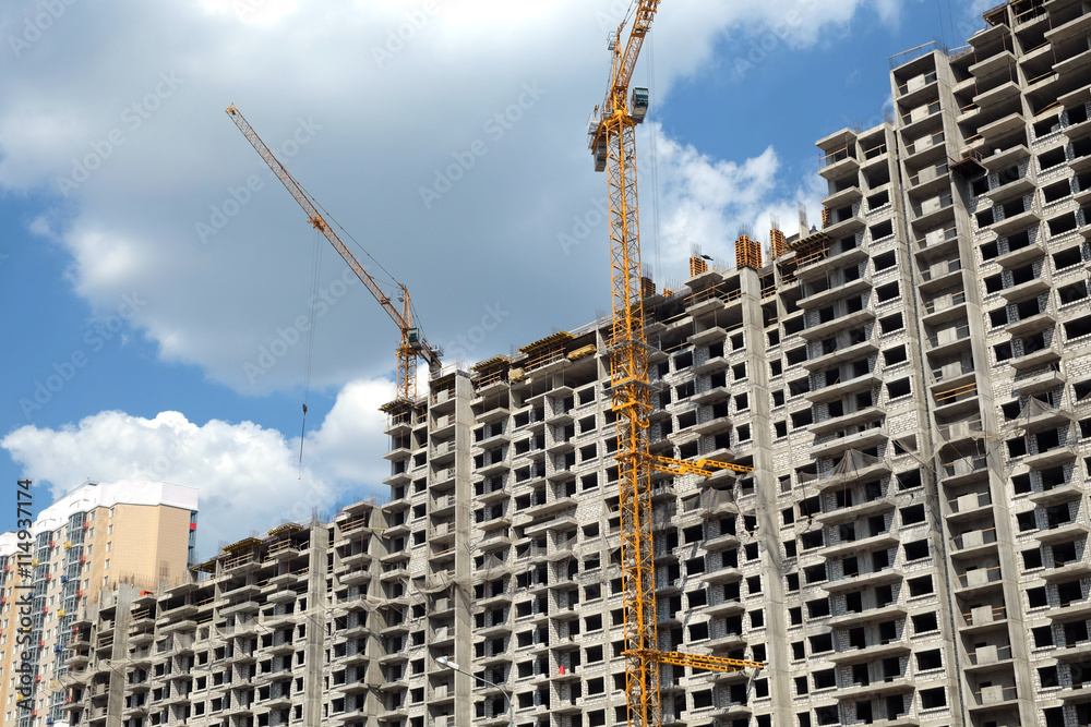 Fototapeta premium New high-rise modern apartment buildings construction in process ob bright sunny day front view horizontal