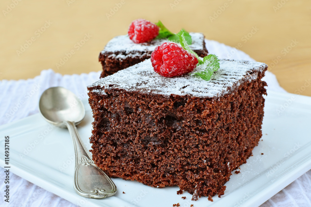 Chocolate brownies with fresh raspberry on white plate closeup Chocolate brownies with fresh raspberry on white plate closeup