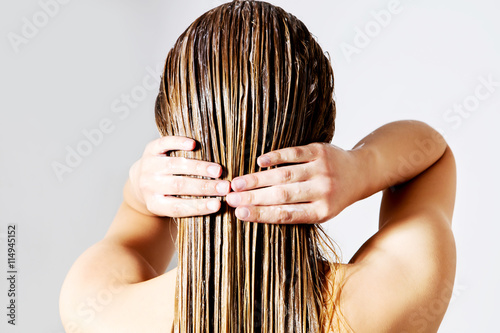 Photographie Femme qui applique un conditionneur de cheveux. Isolé sur blanc.