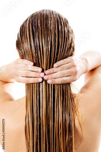 Fotografie Woman applying hair conditioner. Isolated on white.
